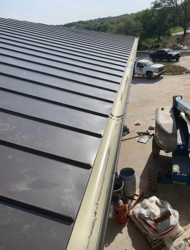 Standing seam panel and gutter detail on a metal roofing jobsite in Gallatin